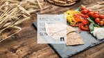 Crispy whole grain crackers with bell peppers, cherry tomatoes and mozzarella on slate